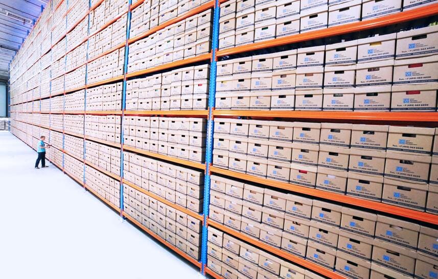 classificação de documentos: inúmeras caixas de documento, de papelão, em uma longa fileira de estantes. 